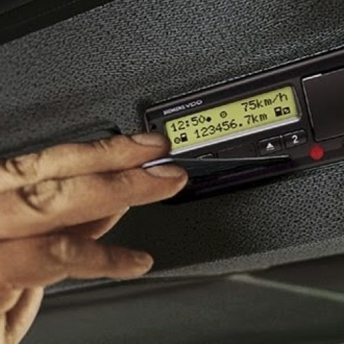 Imagen de una mano introduciendo una tarjeta en un tacógrafo digital